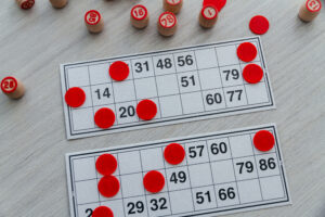 Traditional Russian board game Russian Lotto. Cards with numbers, closeup. Wooden barrels with numbers and a bag with barrels lie on a table